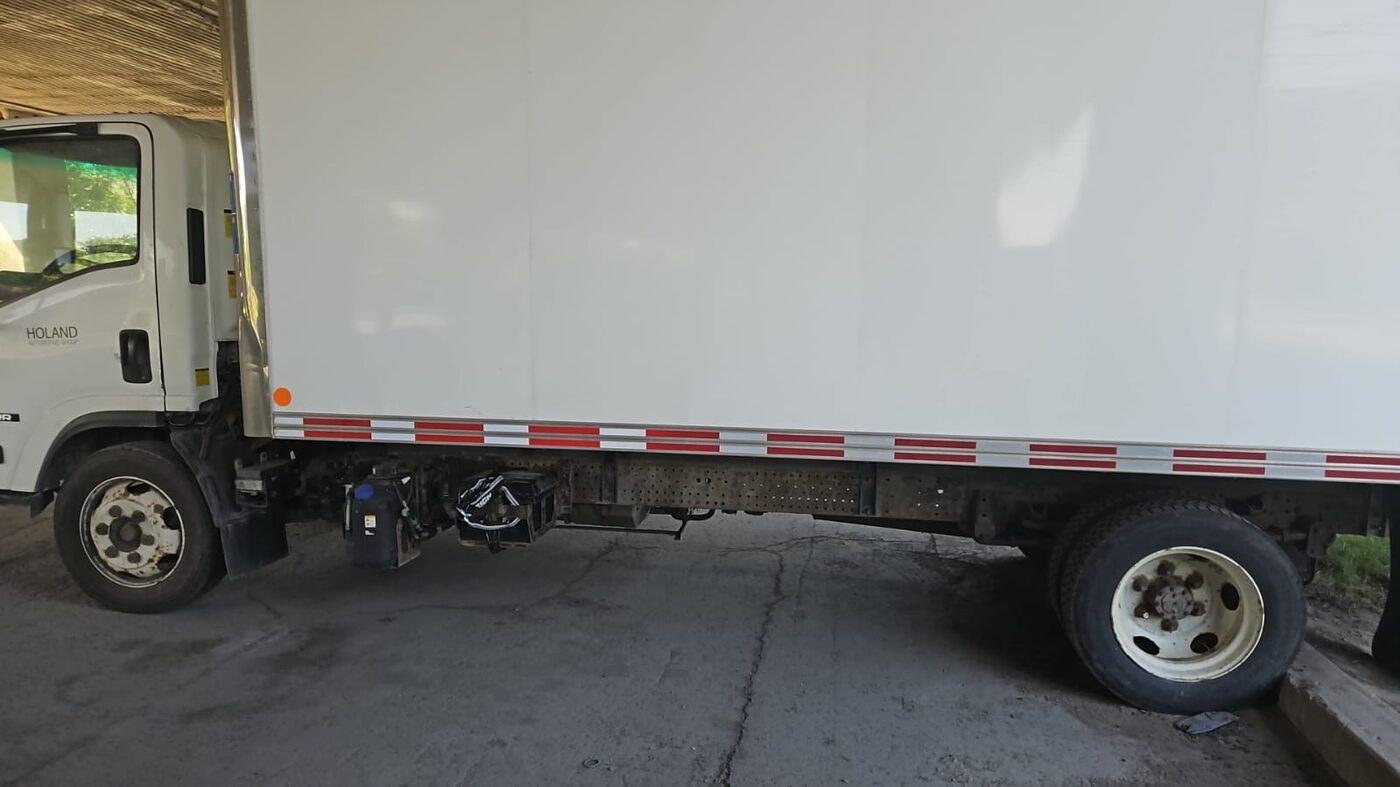 Isuzu diesel cab-over box truck in the VG Well-Being Transport fleet, side profile